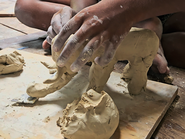 Making elephant with clay in hand